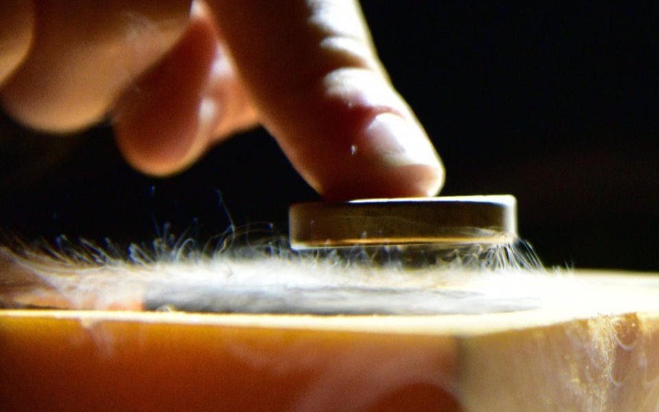 Materials exhibiting superconductivity have a magnetic field that repulses magnets placed on top of it.